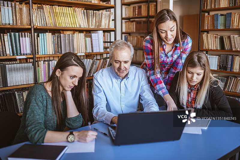 一群学生在图书馆向大学教授请教图片素材