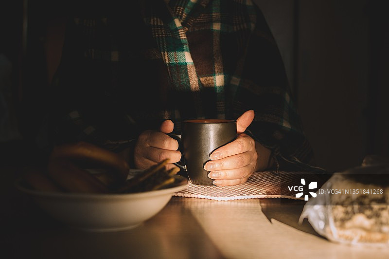 穿着格子披肩的女人用热饮暖手图片素材