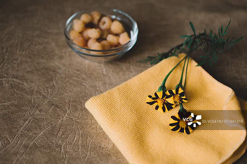 玻璃盘中的黄色覆盆子和万寿菊图片素材