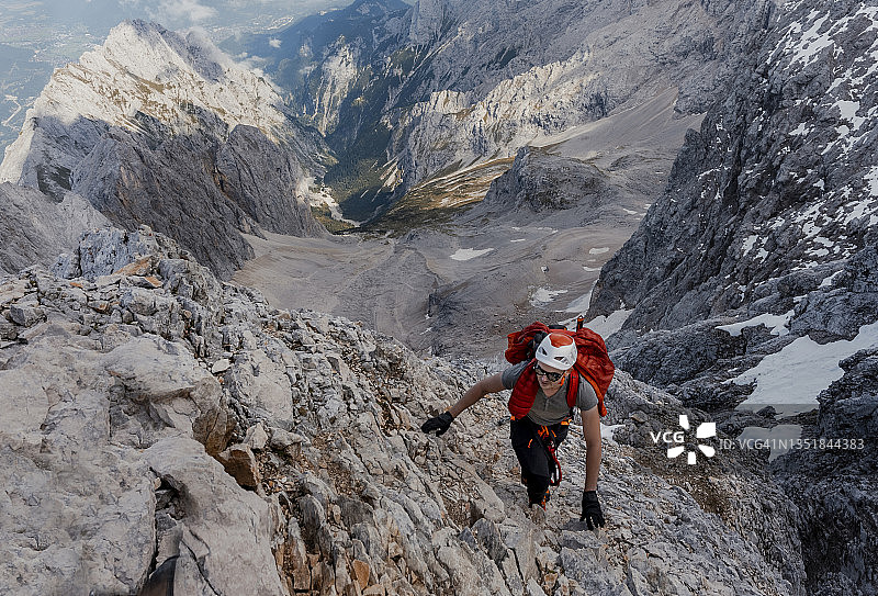 男子攀登陡峭的岩山图片素材
