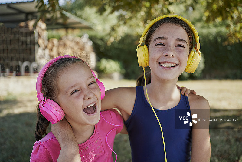 两个女孩在镜头前微笑和大笑的正面图图片素材