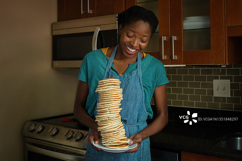 年轻女子对着一堆煎饼大笑图片素材