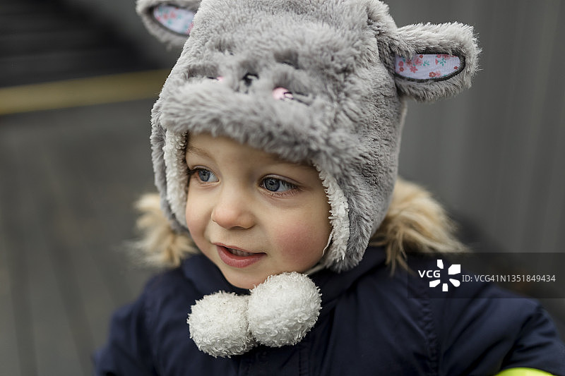 戴灰色毛皮帽微笑着的小男孩图片素材
