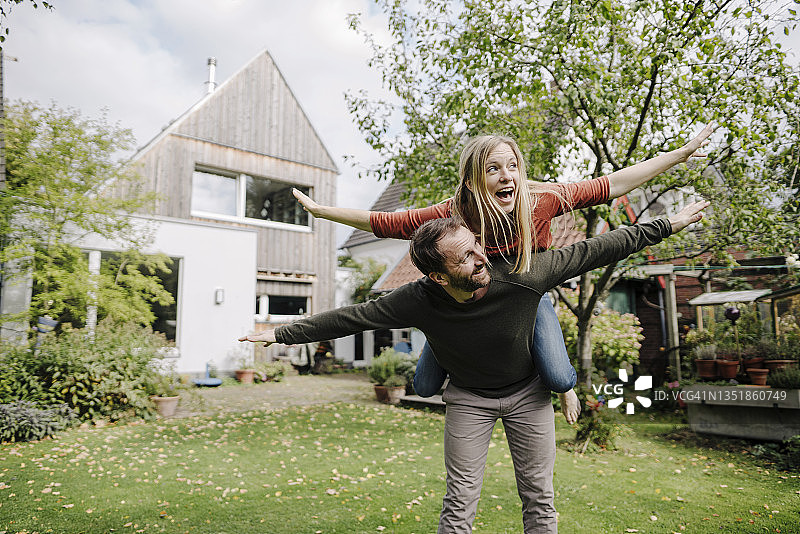 在花园里假装飞翔、欢呼的情侣图片素材