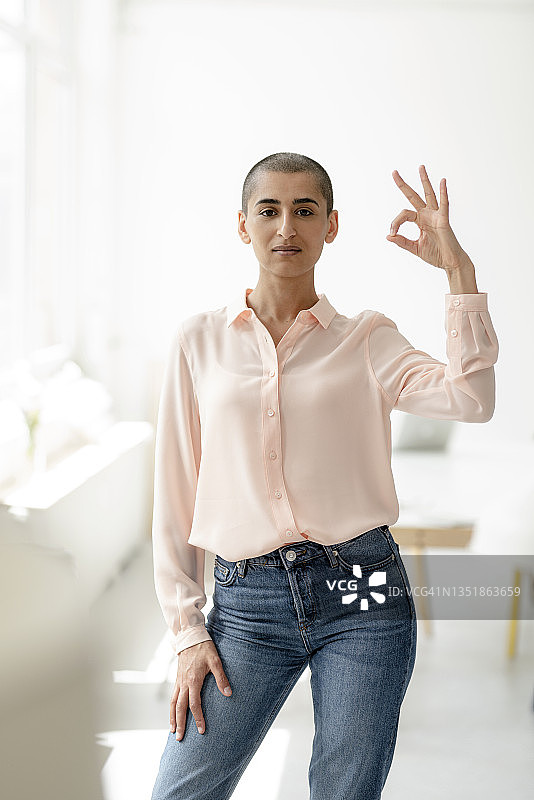 在阁楼里做出OK手势的自信女性肖像图片素材