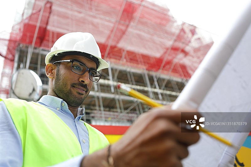 男人看着建筑平面图图片素材