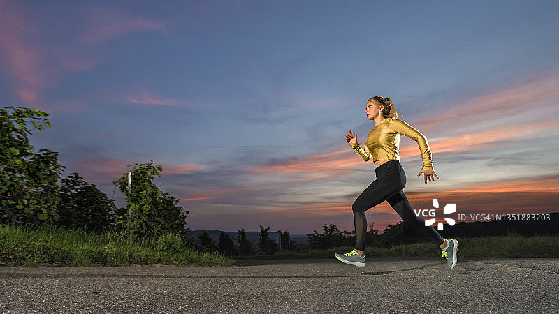 年轻女人在黄昏时独自慢跑图片素材