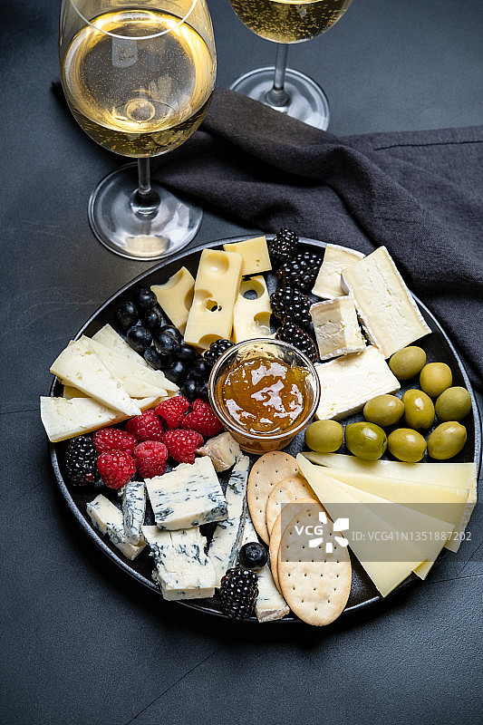 奶酪拼盘（含帕尔马干酪、佩科里诺干酪、古冈左拉干酪、布里干酪、浆果、橄榄、果酱和饼干），适合搭配葡萄酒的开胃菜，节日晚餐或午餐图片素材