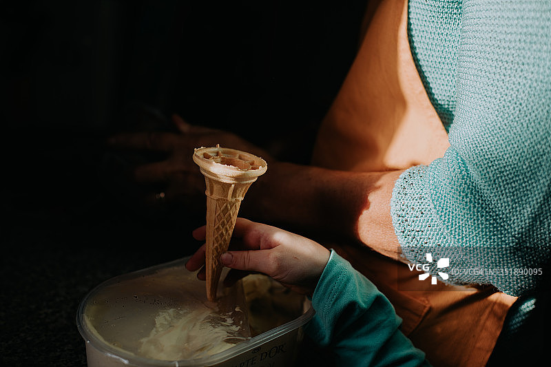 孩子拿着威化冰淇淋甜筒等待大人给冰淇淋图片素材