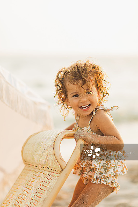 一个可爱的小女孩正在海边的沙滩上玩耍。图片素材