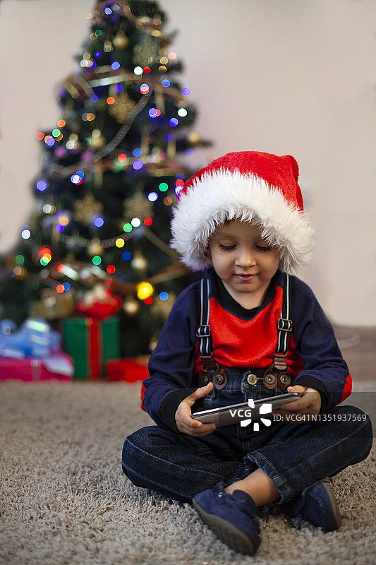 戴着圣诞帽抱着圣诞礼物的宝宝图片素材