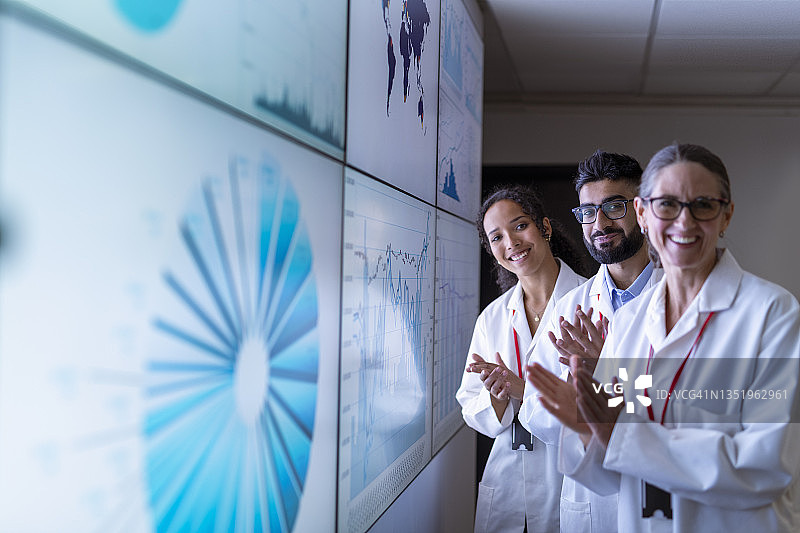 英国约克研究人员在互动屏幕前祝贺同事图片素材