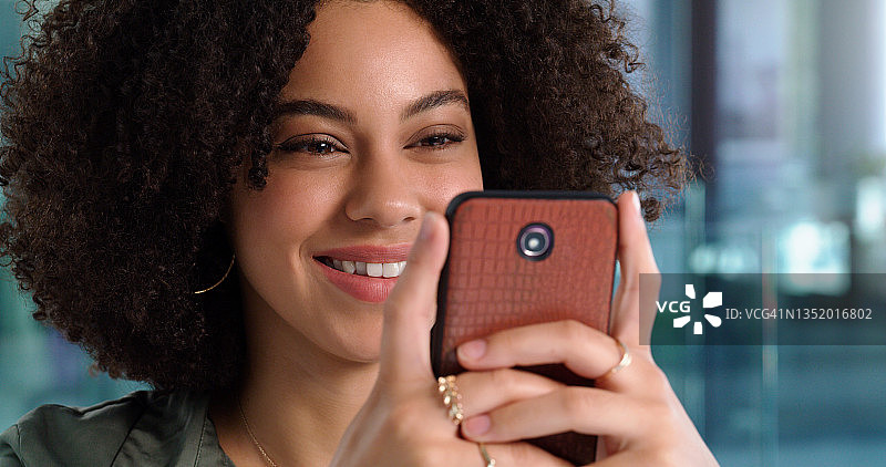 年轻女子在工作场所使用手机图片素材