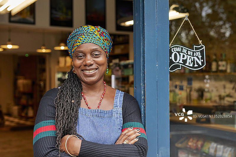 站在商店门口的黑人女店主肖像图片素材