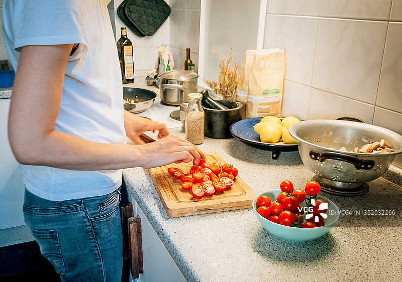 在厨房准备蔬菜晚餐的女性侧视图图片素材