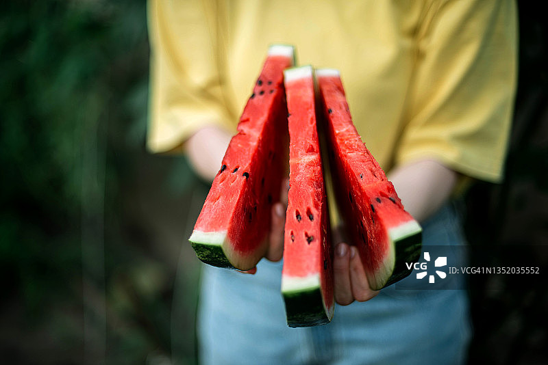 一位女士在花园里拿着西瓜图片素材