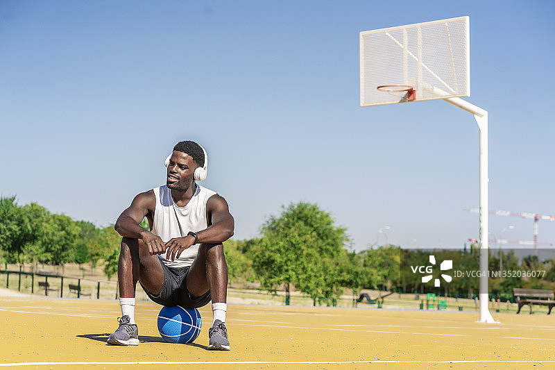 篮球运动员用智能手机听音乐图片素材