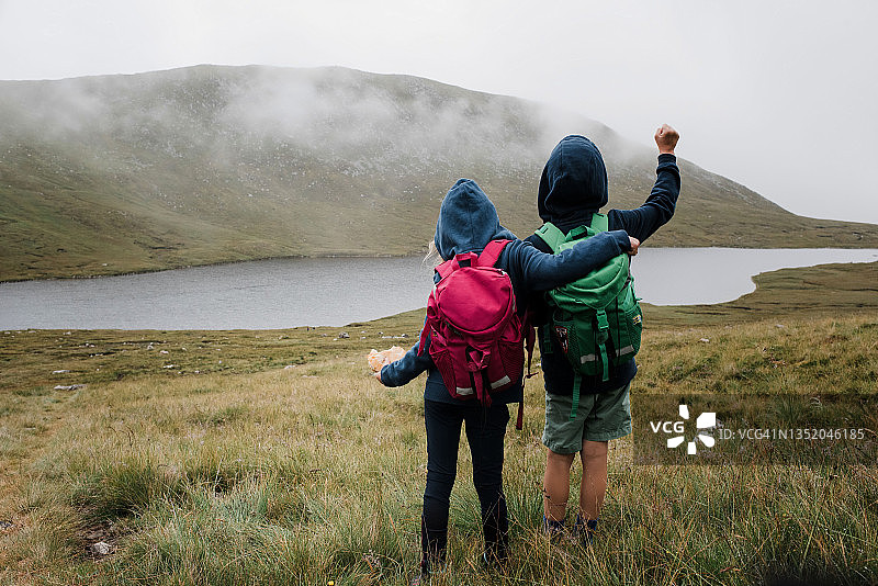 兄弟姐妹在英国斯卡费尔峰拥抱欣赏风景图片素材