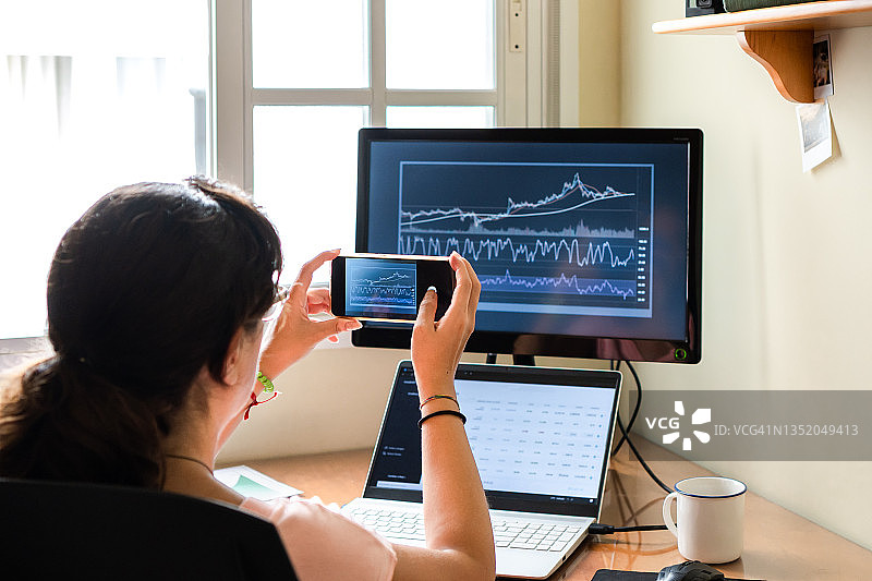 居家办公的女商人查看股票图表图片素材