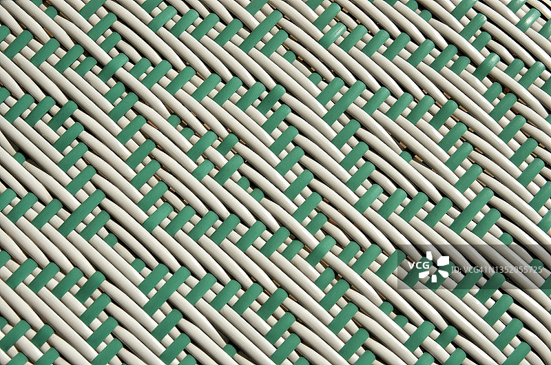 塑料藤条/柳条户外家具上的双色绿白菱形编织图案图片素材