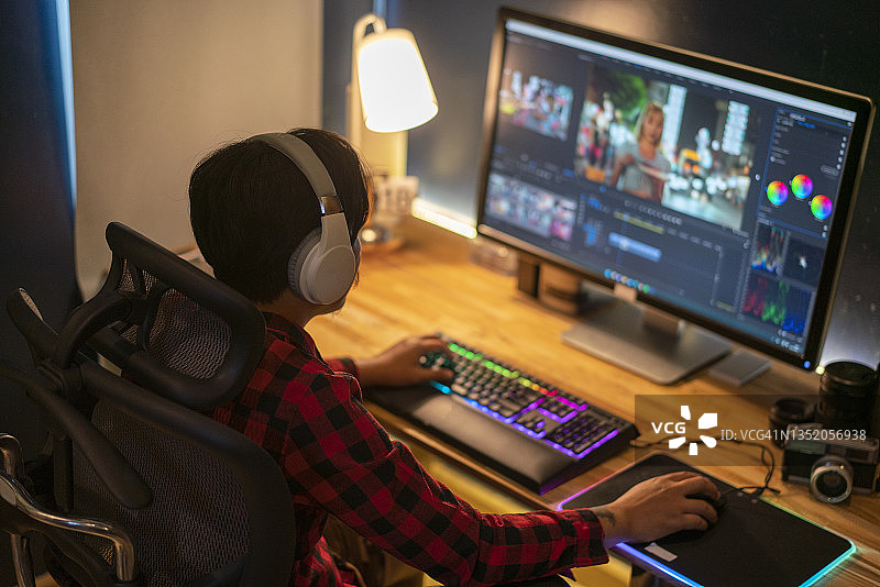 男人戴着耳机在电脑上进行视频编辑图片素材