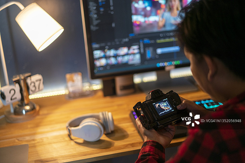 在办公桌前使用相机的摄影师图片素材