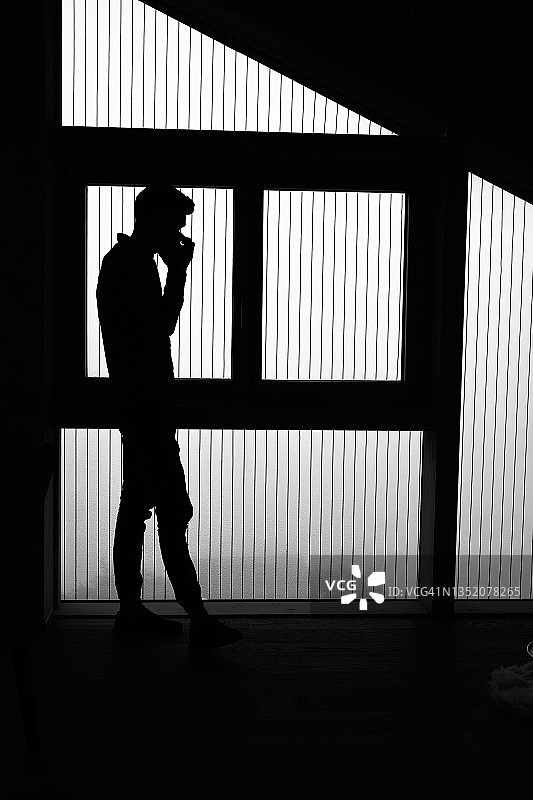 在剪影中，年轻人正在打电话图片素材