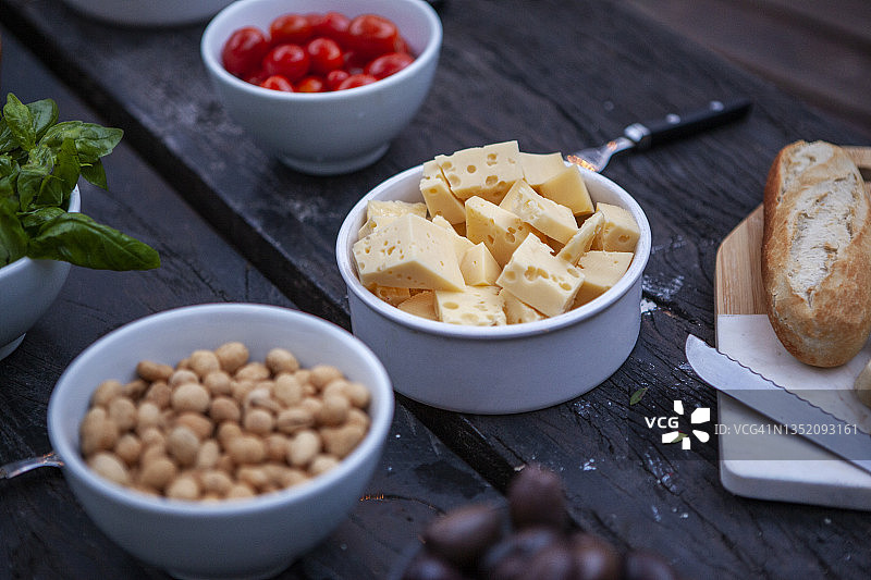 盛满奶酪、面包、花生和圣女果的木桌图片素材