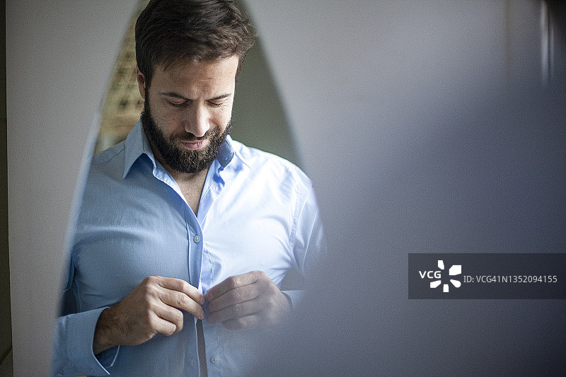 成年男子扣衬衫的镜像图片素材