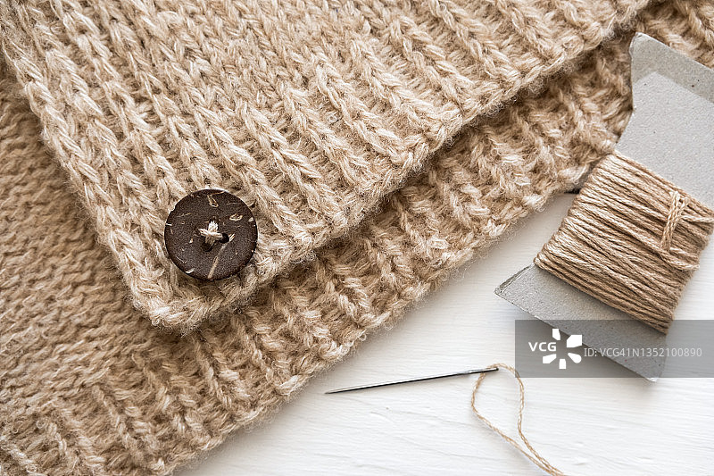 缝在针织毛衣上的纽扣特写图片素材