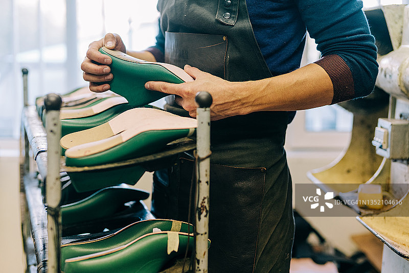 鞋匠在工作室里拿着鞋楦图片素材