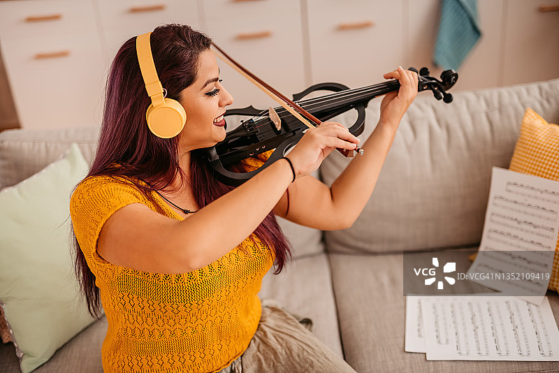 年轻的小提琴手在家练习演奏图片素材