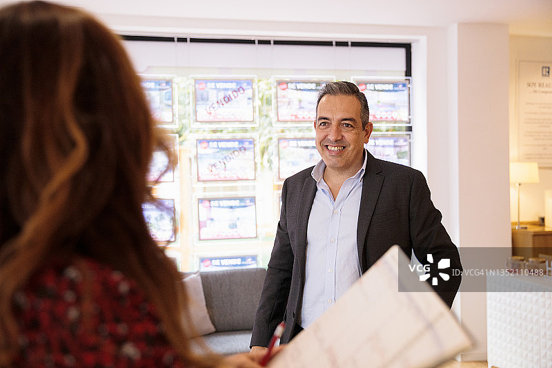 微笑的商人在办公室与女商人交谈图片素材
