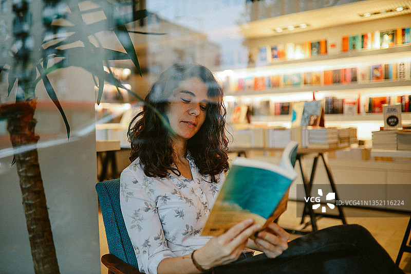 女人坐在咖啡书店里，正在看书图片素材
