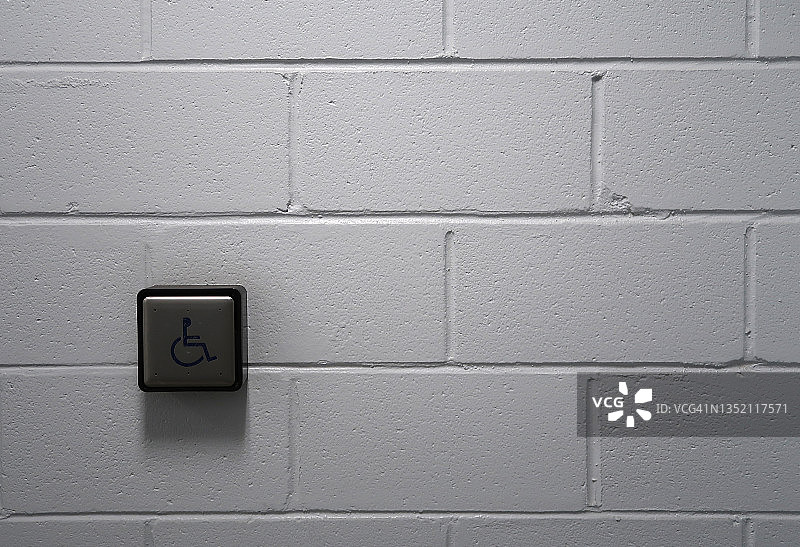 白色砖墙上的自动开门按钮图片素材