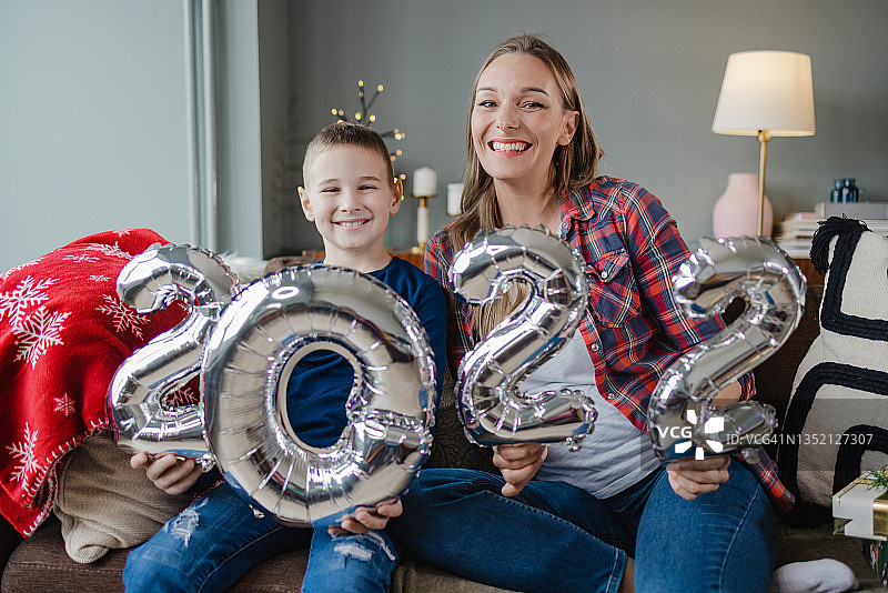 手持2022数字气球的母子肖像图片素材