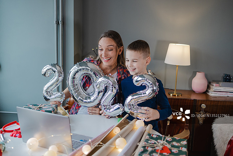 母子拿着2022数字气球在线庆祝新年图片素材