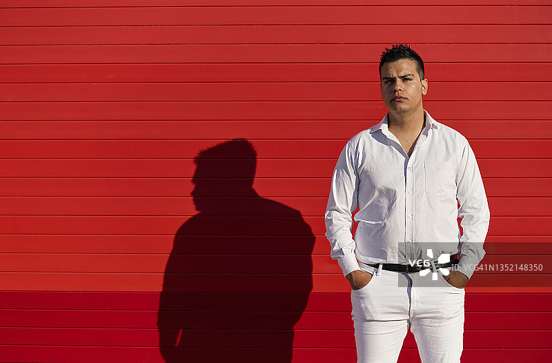 男人身穿白色衣服，手插口袋看着镜头图片素材