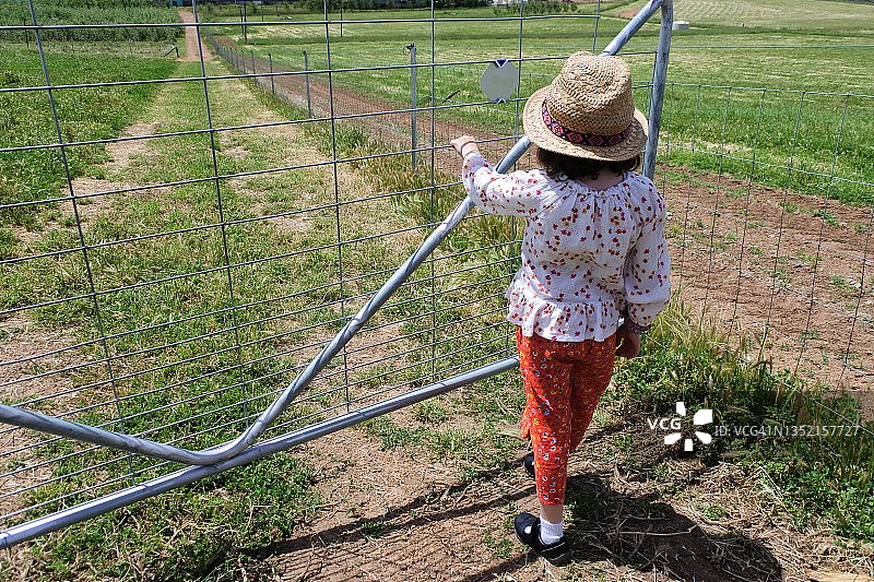 年轻女孩打开农场大门图片素材