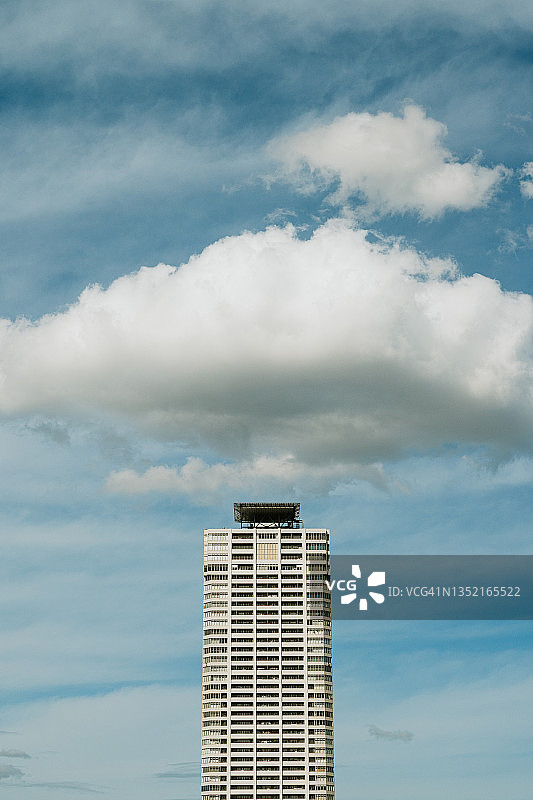 摩天大楼顶部与斗笠状云朵图片素材
