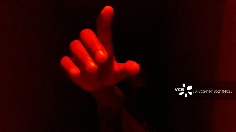 红光和黑色背景中不同的手势图片素材