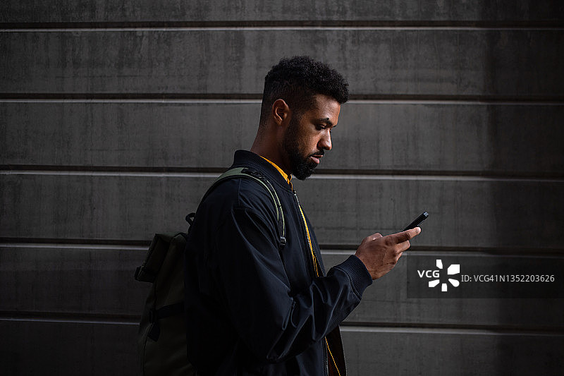 在城市中用智能手机通勤的年轻男人，可持续的生活方式图片素材