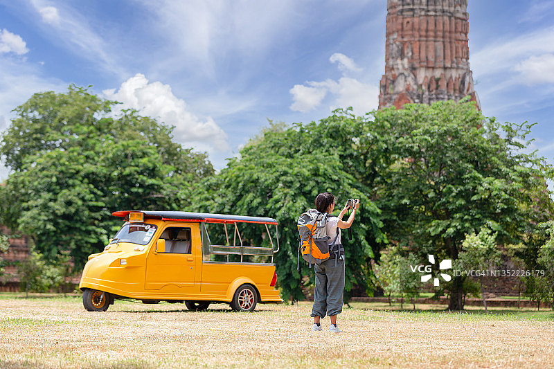 年轻的亚洲女游客在泰国阿瑜陀耶府玛哈泰寺拍照图片素材