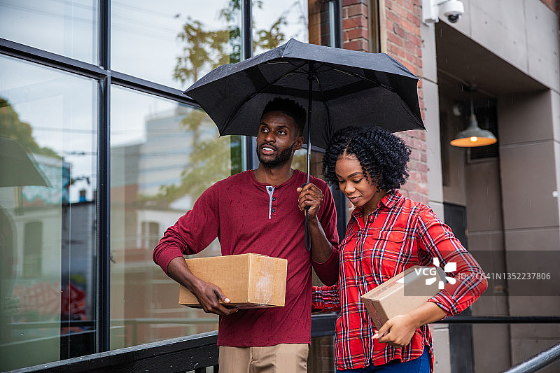 非裔美国夫妇抱着纸箱包裹前往邮局图片素材