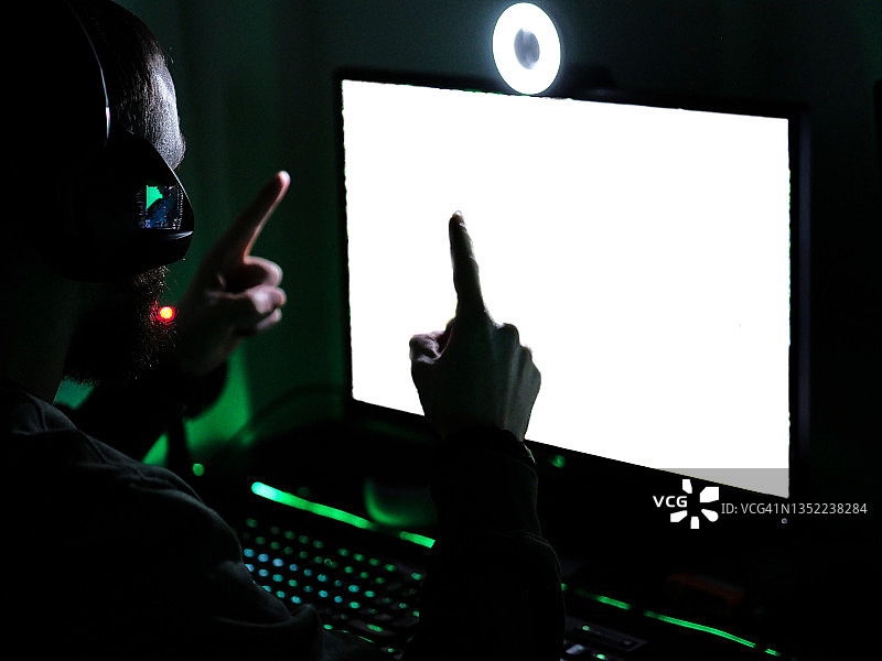 男人通过直播庆祝胜利，配备RGB键盘和网络摄像头图片素材