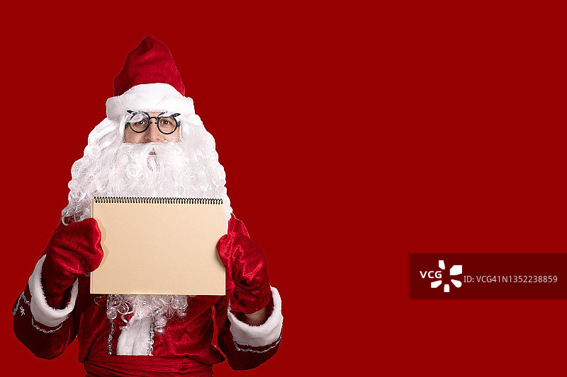 圣诞节：慈祥的圣诞老人拿着一个空纸板框架，广告位，文本位，空位图片素材