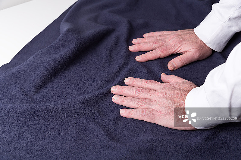 裁缝裁剪布料的特写。服装商在工作中裁剪布料。图片素材