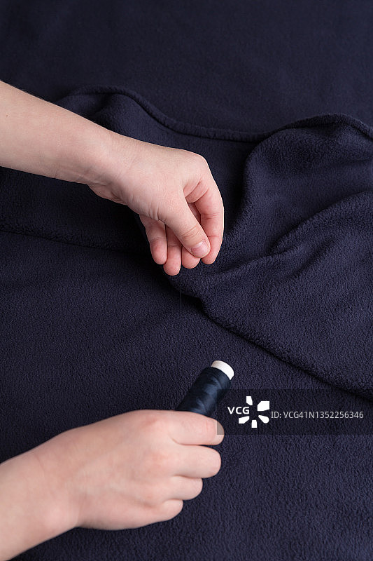 裁缝裁剪布料的特写。服装商在工作中裁剪布料。图片素材