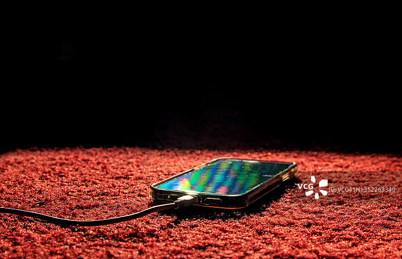 黑色背景地板上的智能手机图片素材