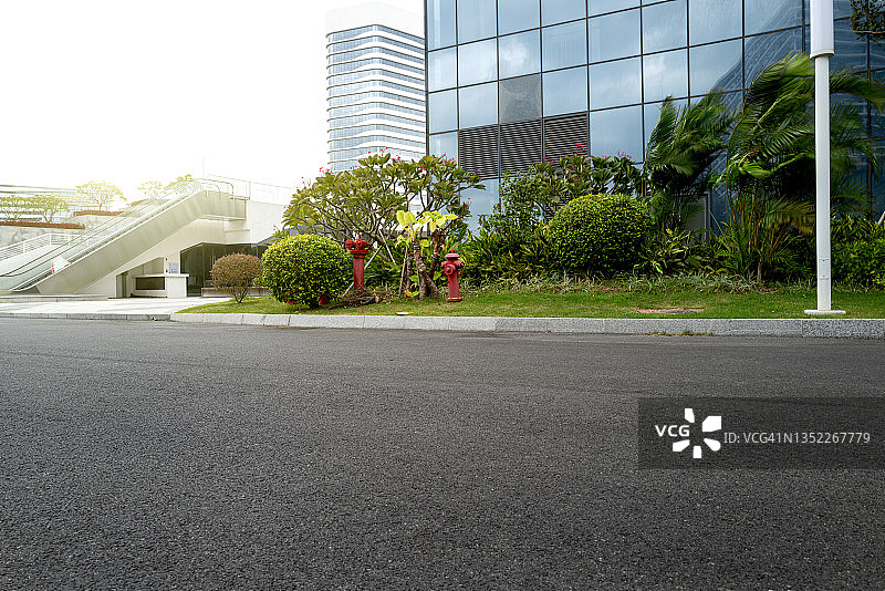 现代玻璃幕墙建筑外的空旷沥青道路图片素材
